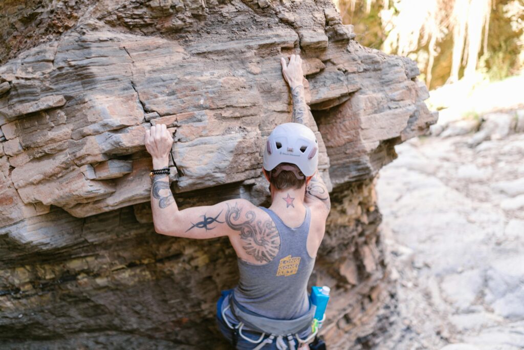 Climber using open-hand grip on vertical wall to reduce wrist extension load